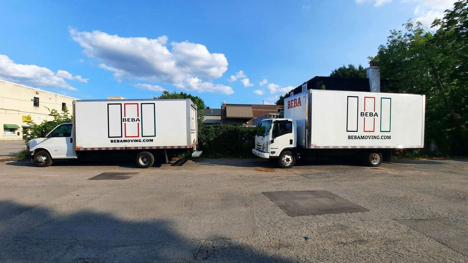 Two BEBA moving trucks parked in an Ottawa yard at sunrise